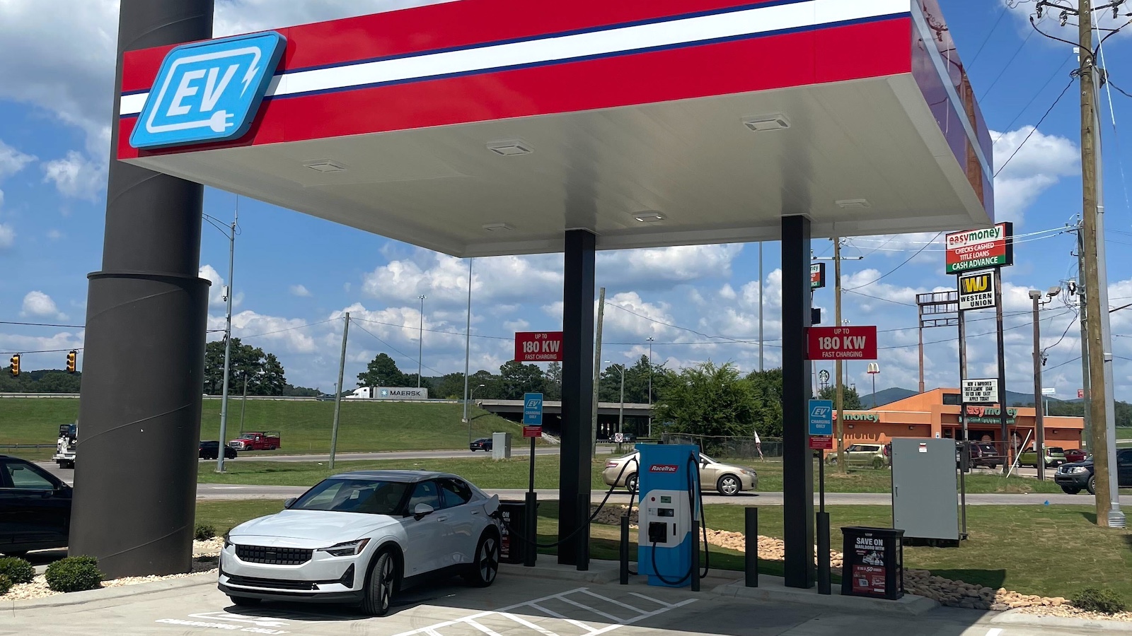 An electric vehicle is plugged into a Level 3 "fast charger" at a Racetrac convenience store.