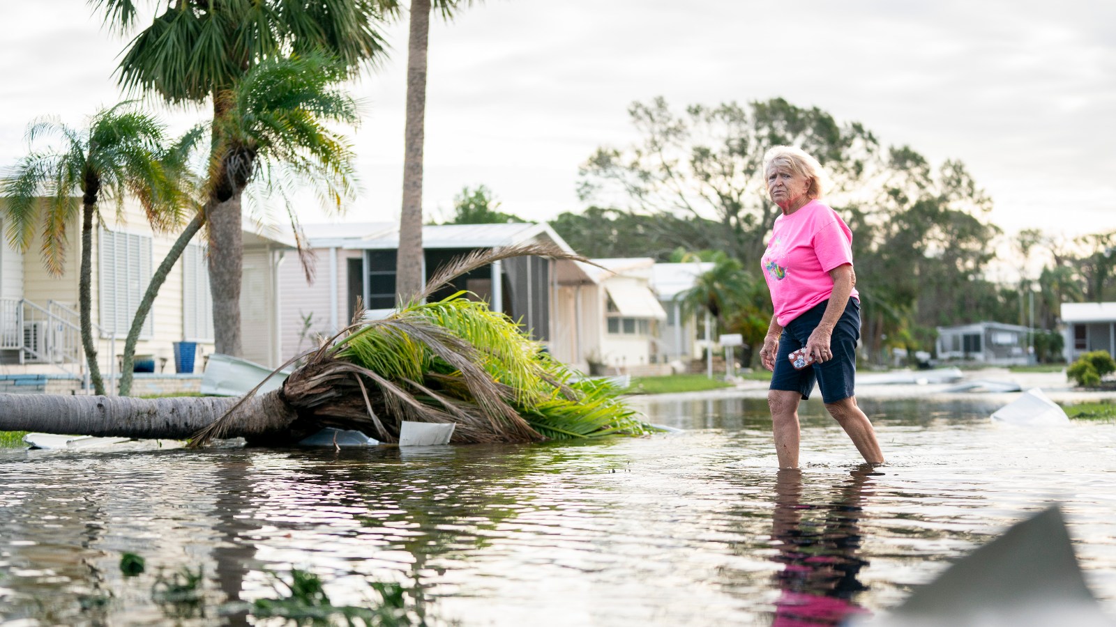 A woman walks along a flooded street in the aftermath of Hurricane Milton on October 10, 2024 in Osprey, Florida.