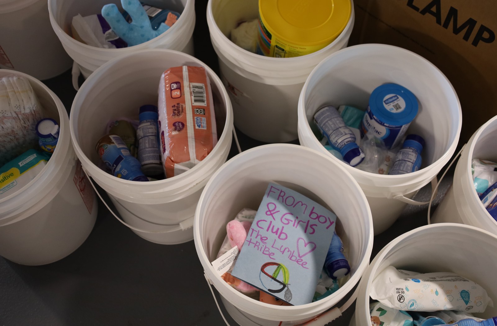 An overhead view of buckets filled with hygiene items, and a hand-written card