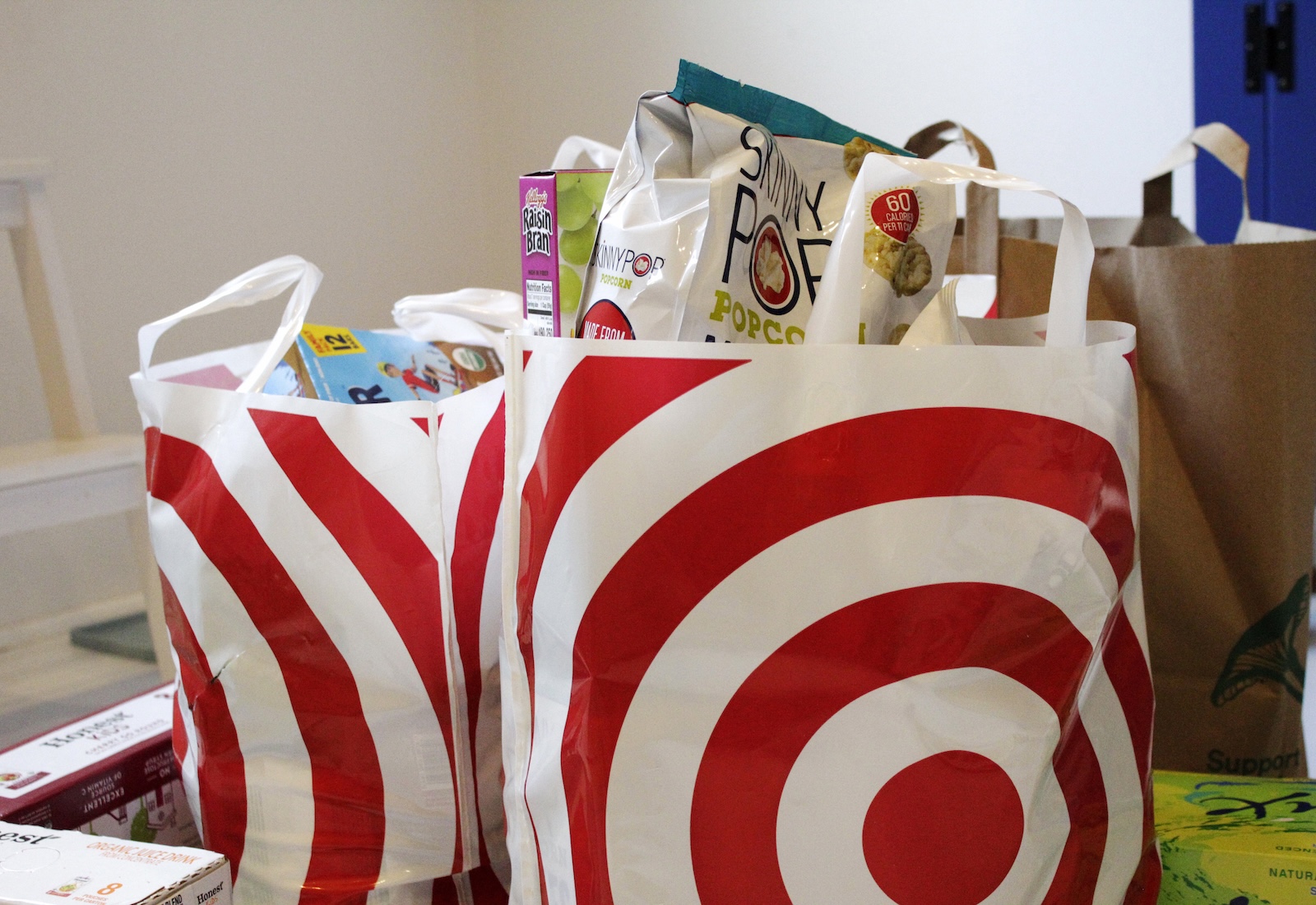 Two Target-branded grocery bags sit on a table, full of groceries.