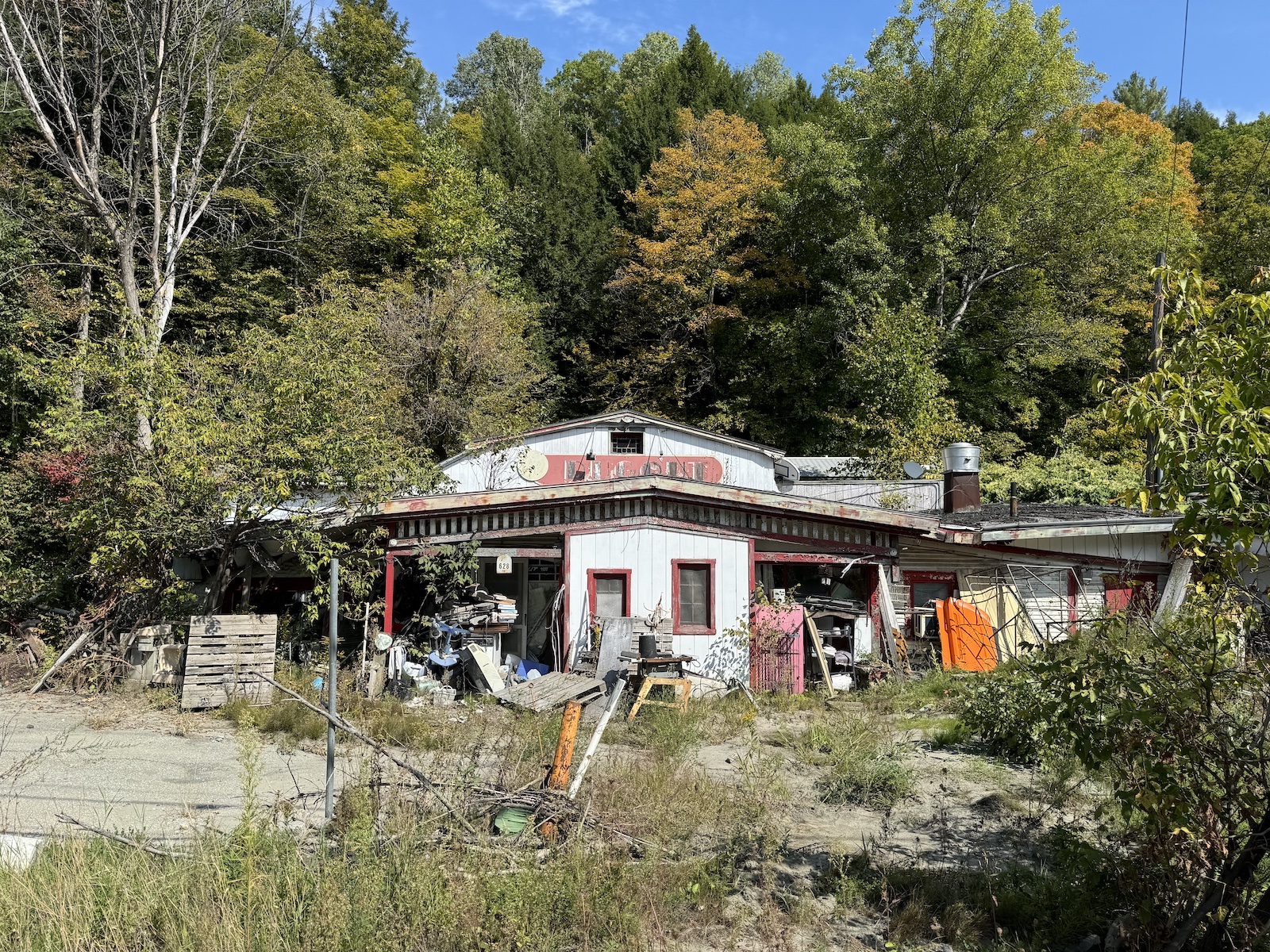 A dilapidated house with orange trim