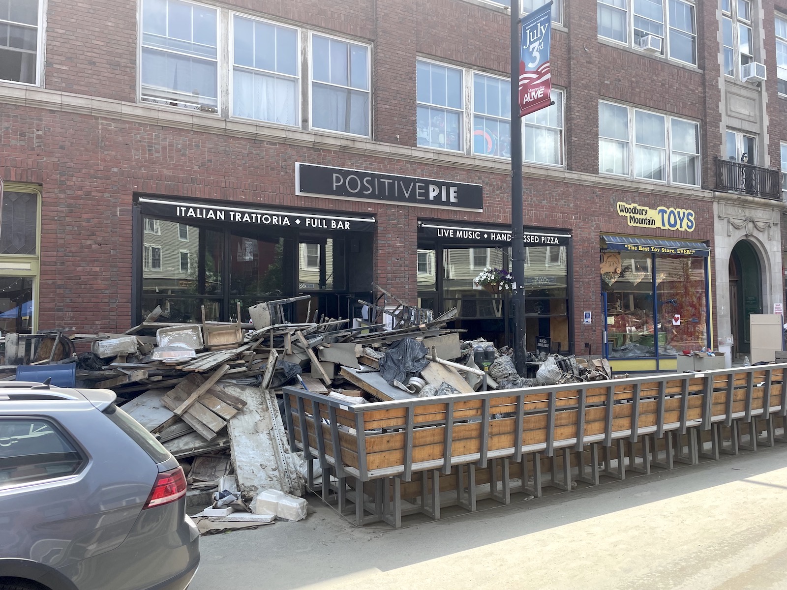 garbage and damaged furniture piled up outside a business called positive pie