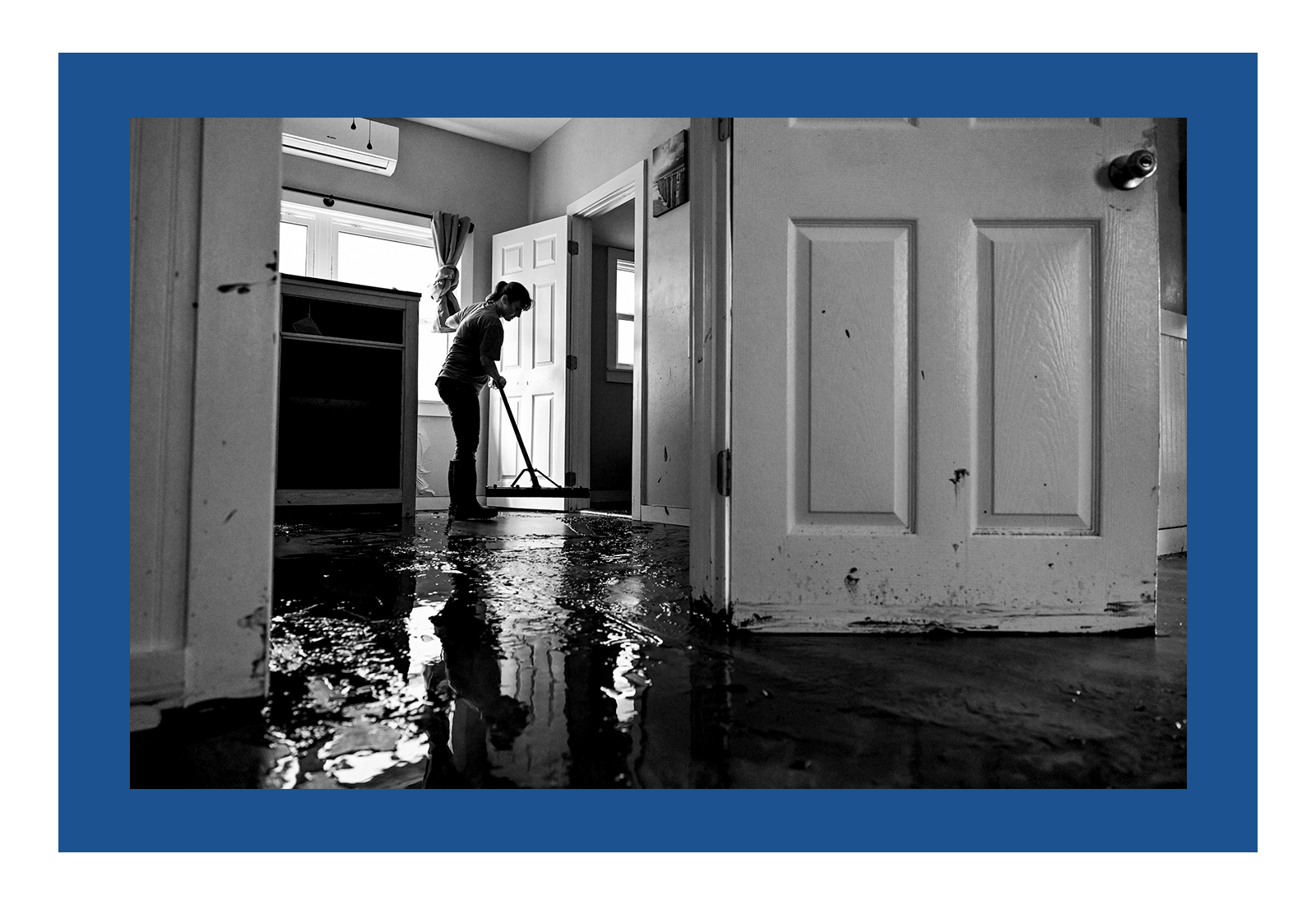 A woman cleaning her house after Hurricane Helene made landfall in Cedar Key, Florida