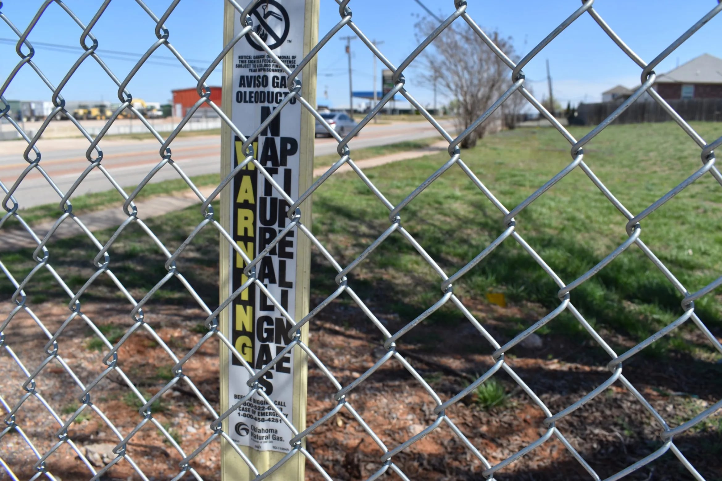 A gas pipeline sign behind a chain link fence