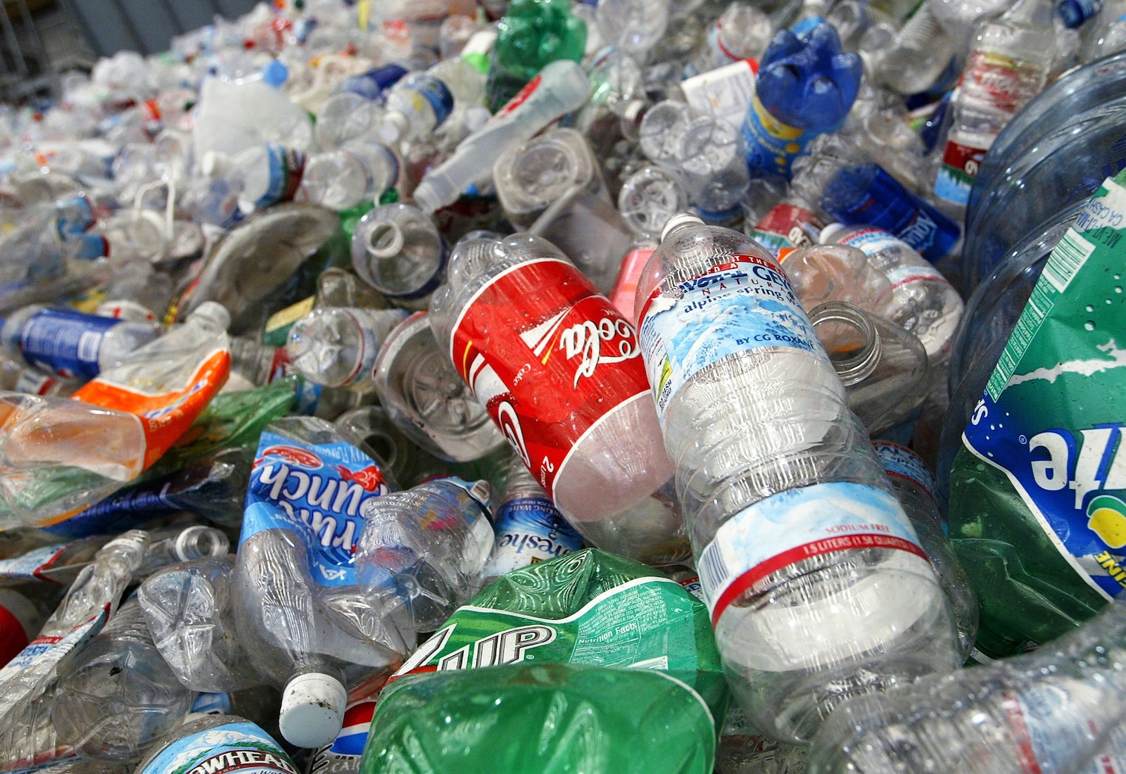 Pile of plastic bottles, with Coca-Cola logo visible on one in the center.