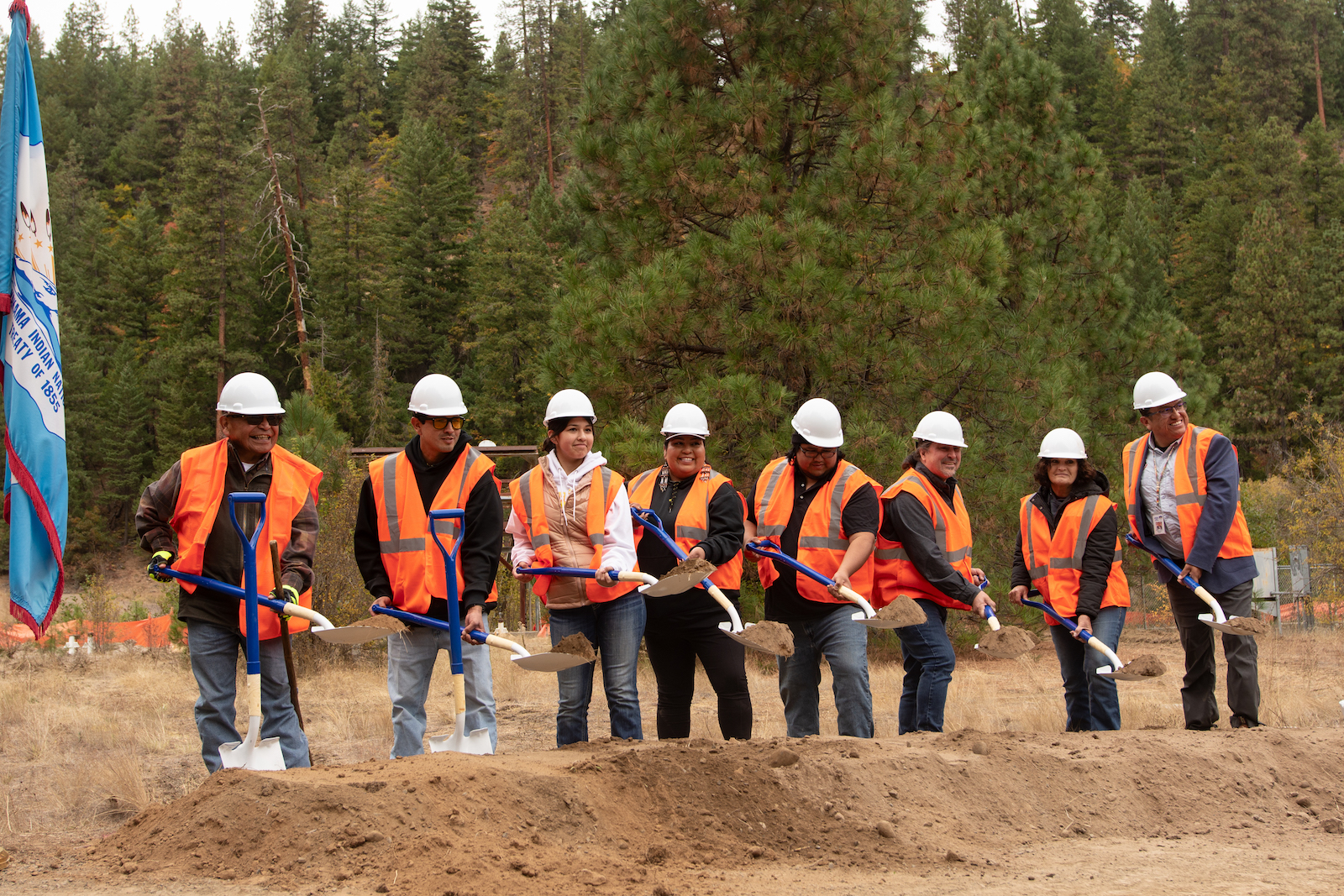 A group of people in construction vests digging