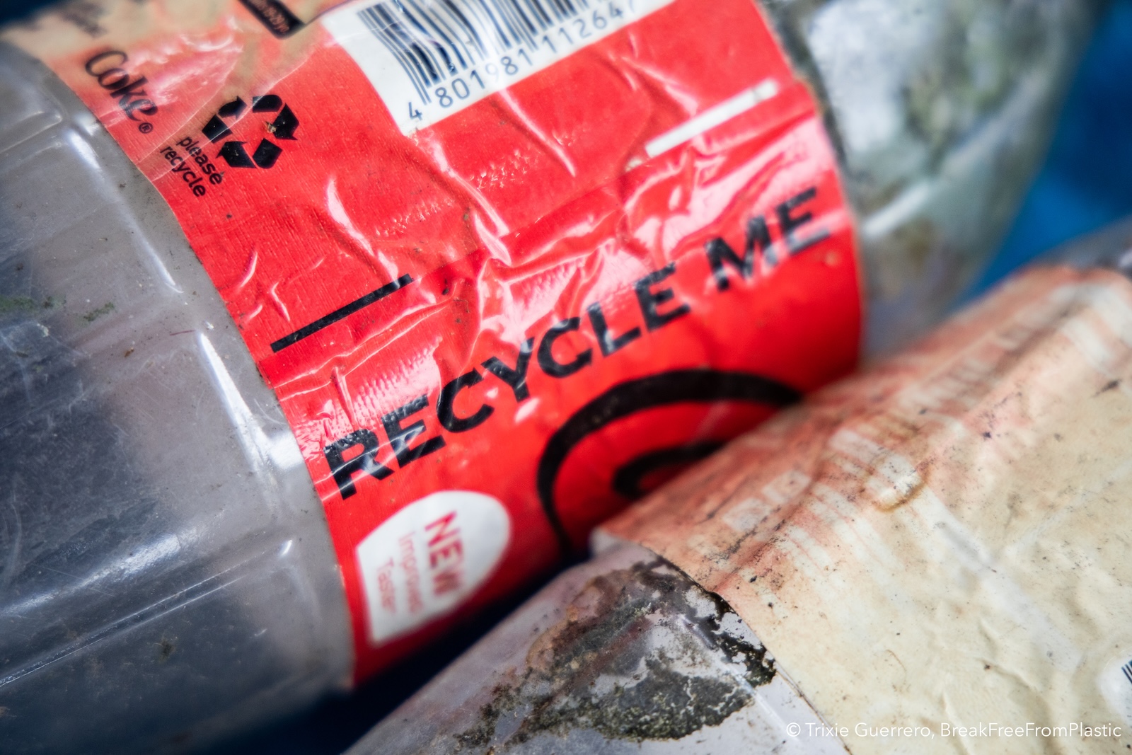 Close-up of Coke bottle label reading "Recycle Me"