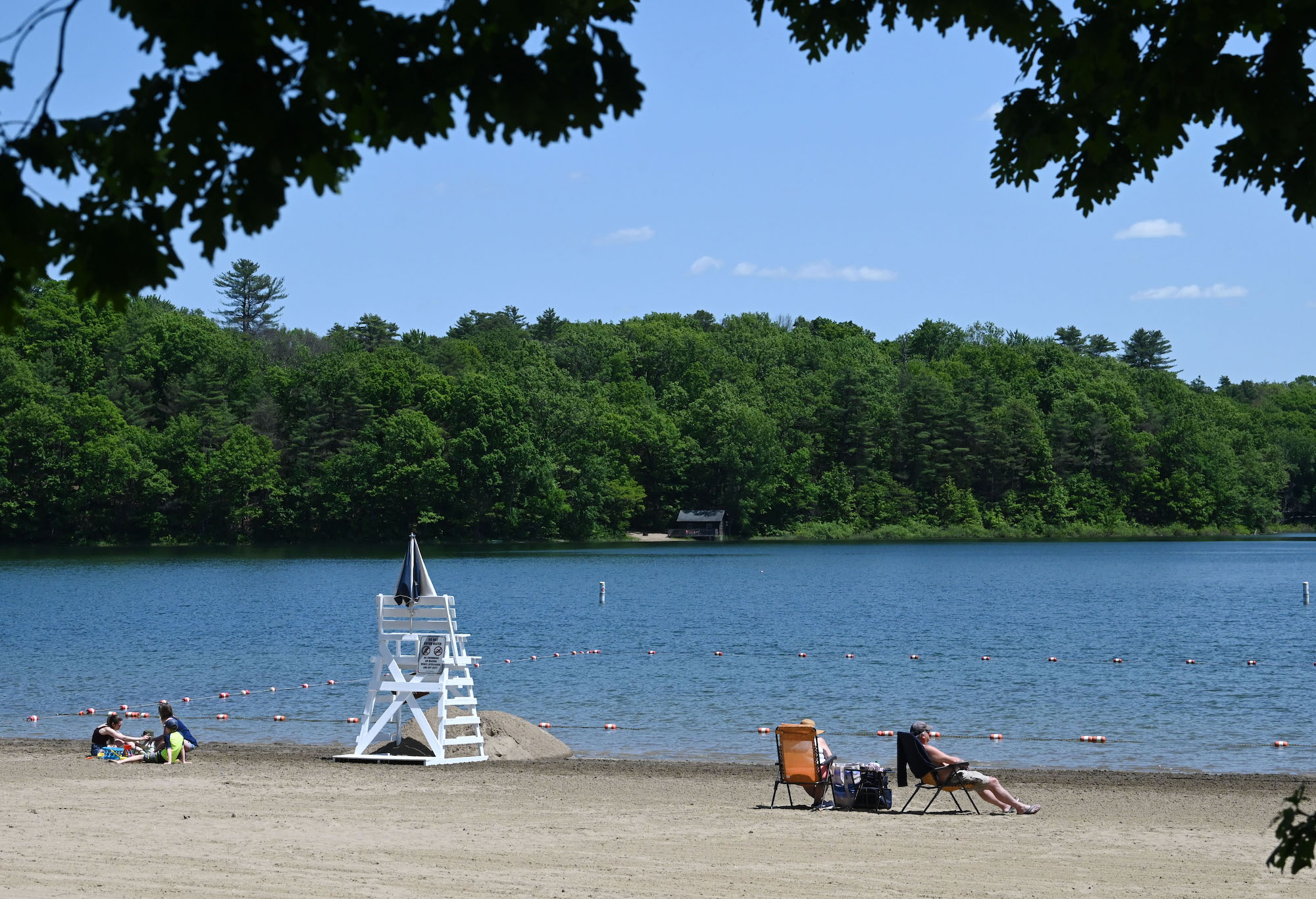 A blue lake with beach and lifeguard chair