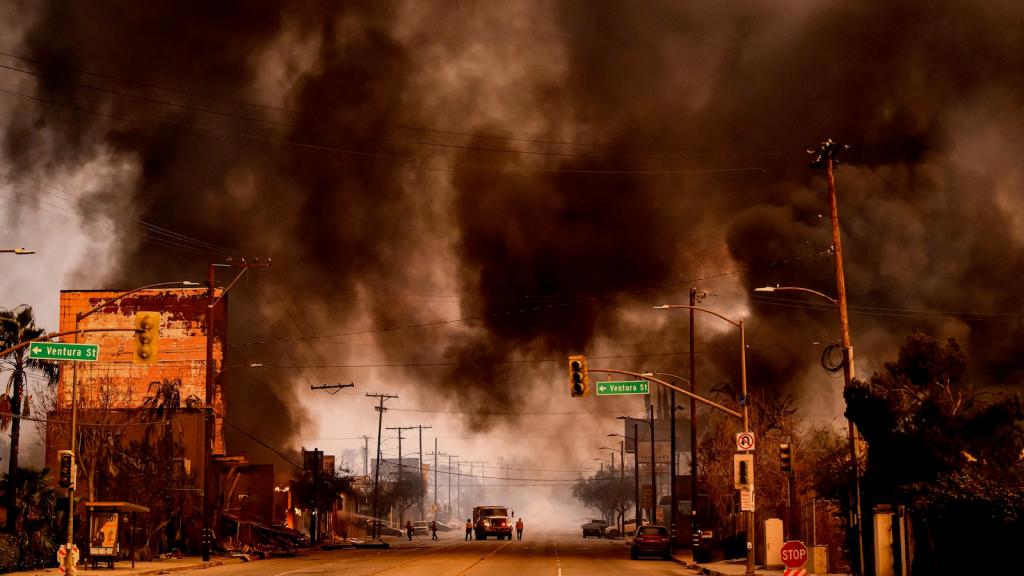 Black smoke fills the sky over a neighborhood burning in Los Angeles.