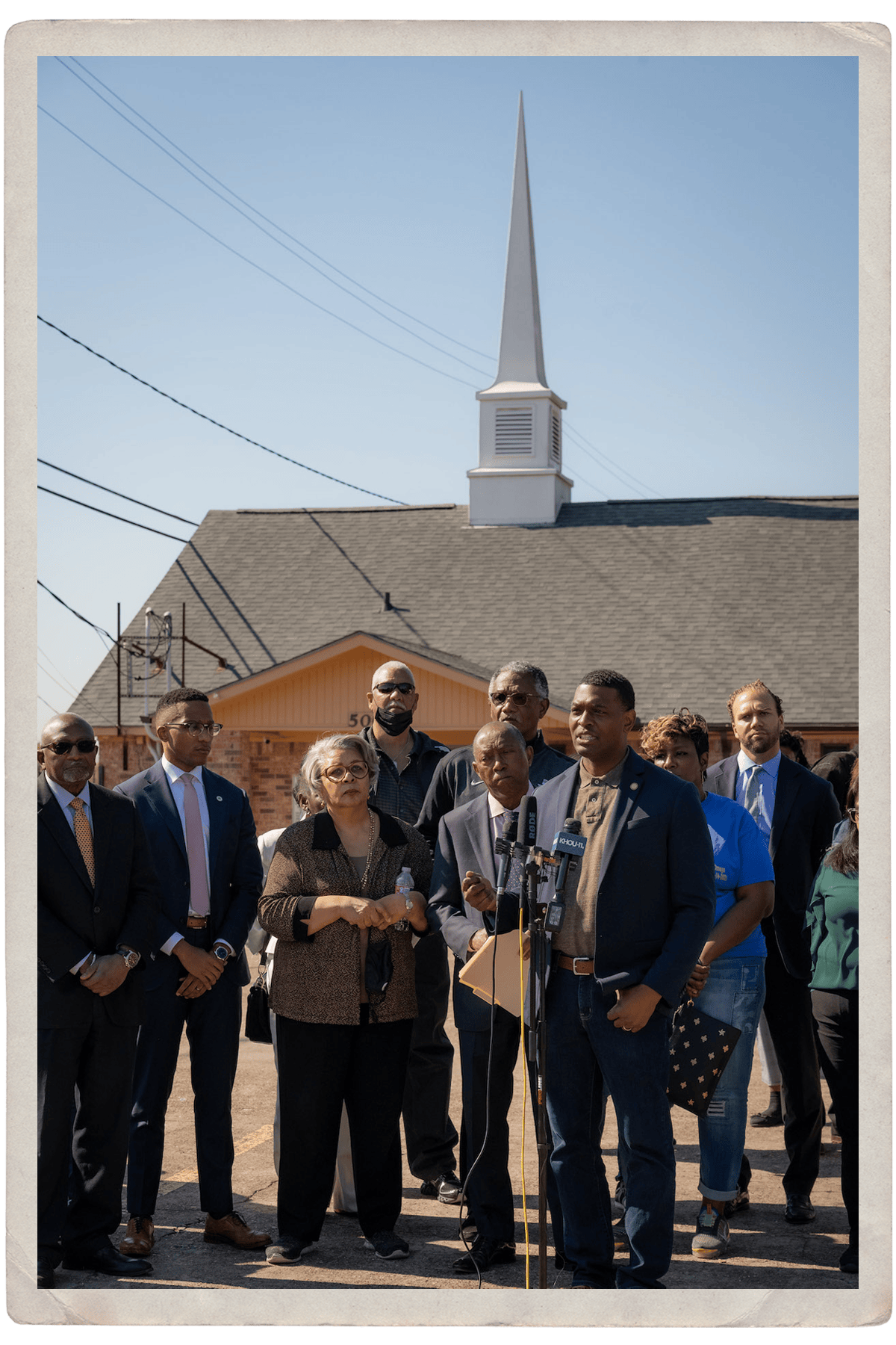 A group of people stand in front of a church