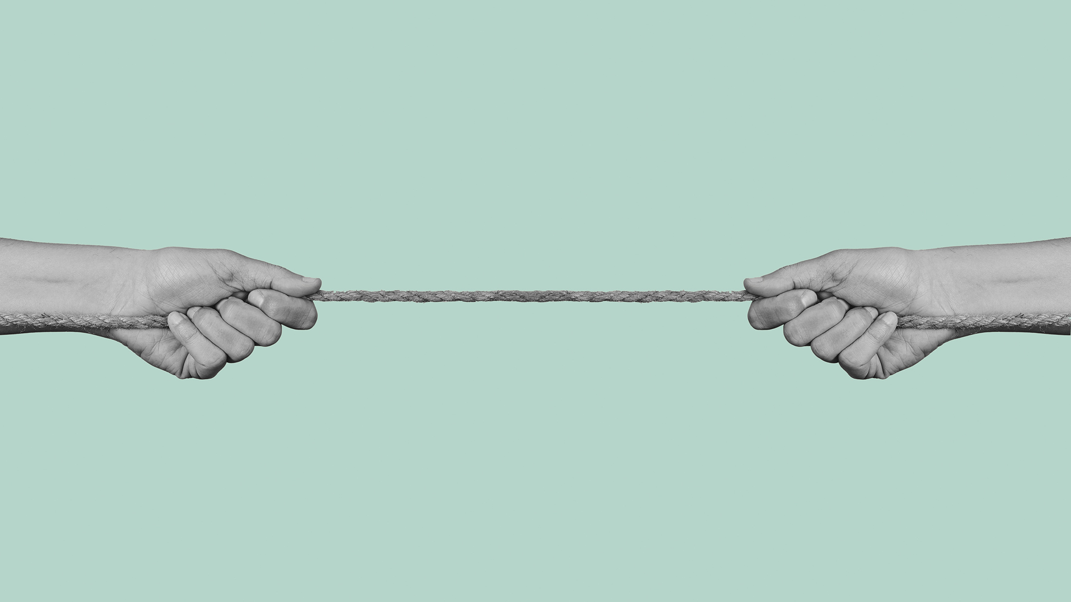 Two hands pull at opposite ends of a rope