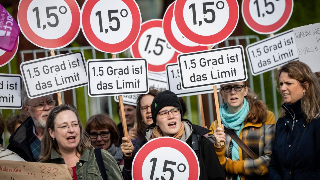 Photo of protesters holding many circular signs saying 1.5 degrees