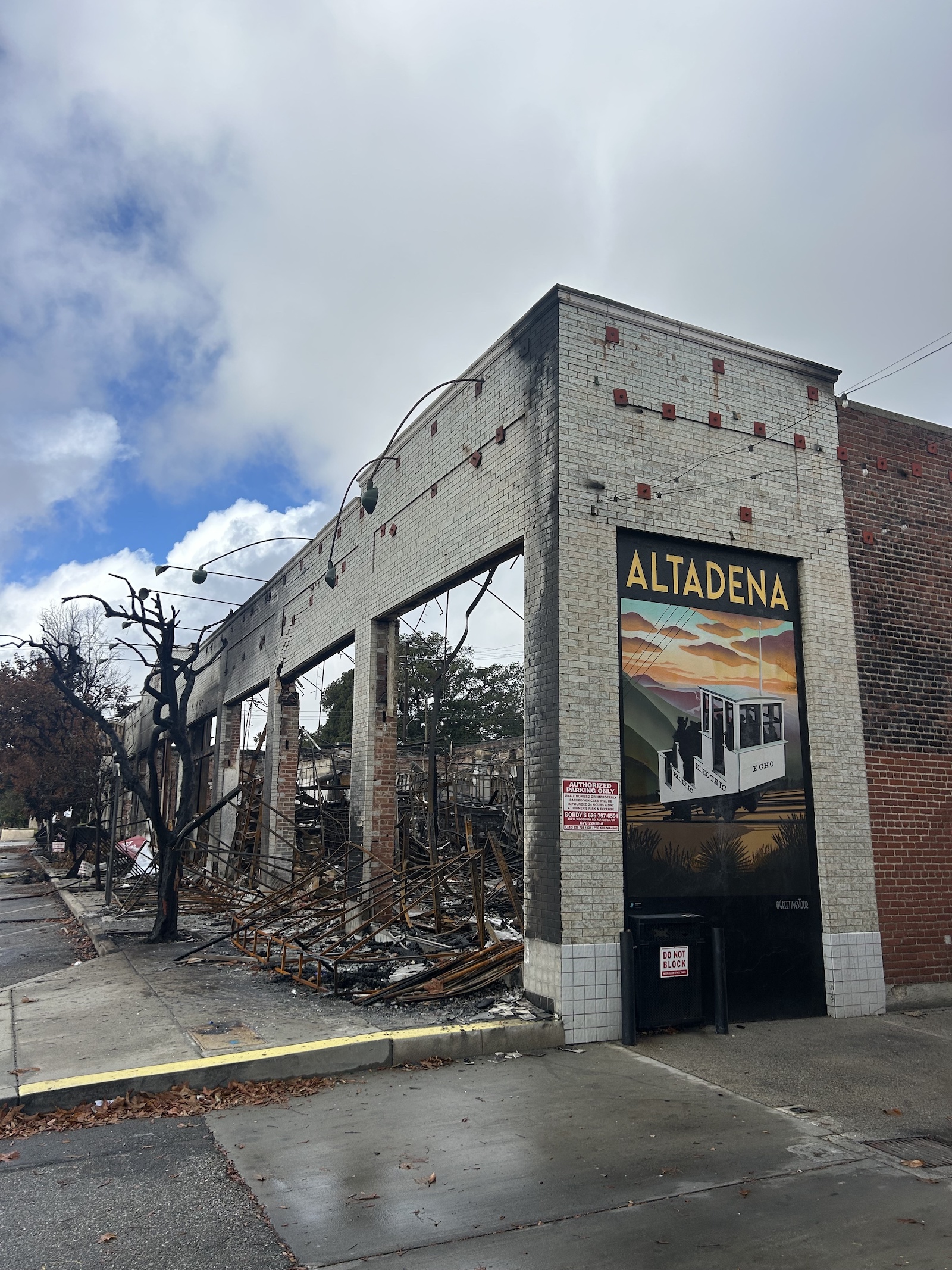 A partially burned building with a large 'Altadena' mural