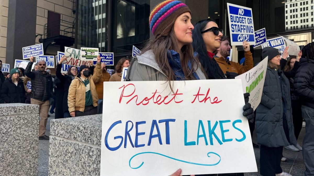 A woman carries a sign that says"Protect the Great Lakes"