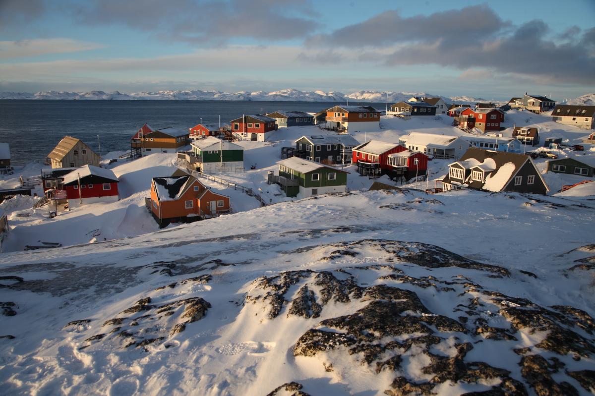 A snowy village near a fjord