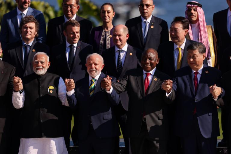 Presidents of various countries stand holding hands