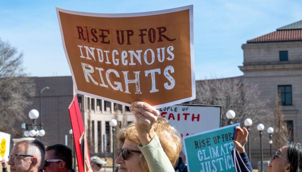A protestor in Minnesota holds up a sign saying Rise Up for Indigenous Rights