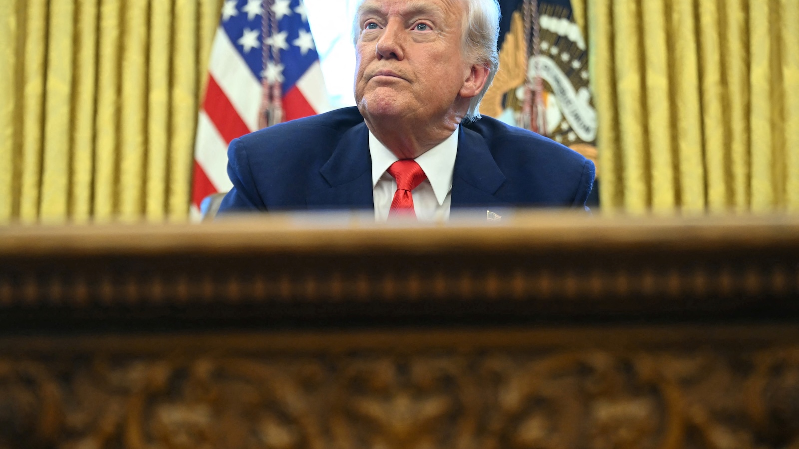 US President Donald Trump looks on after signing an executive order in the Oval Office.