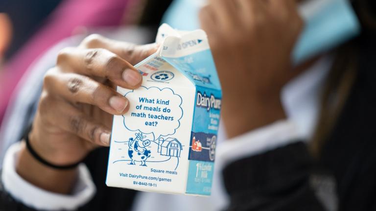 close-up of a student holding a carton of milk