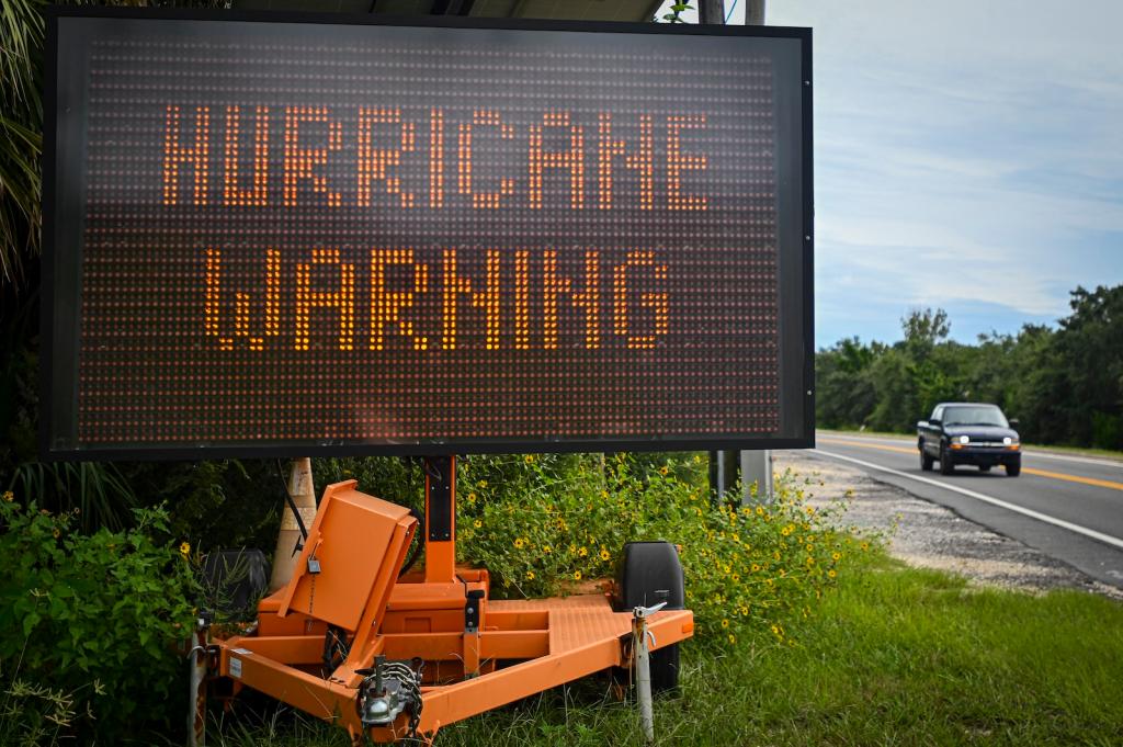 A sign displays a hurricane warning along a roadside as preparations are made for the arrival of Hurricane Helene, in Cedar Key, Florida on September 25, 2024.