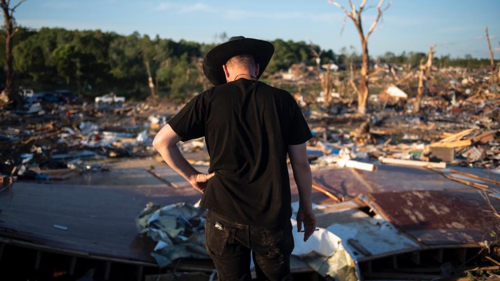 A man surveys the remains of the home where his father and step-mother lived. They were among those killed when a tornado hit London, Kentucky.