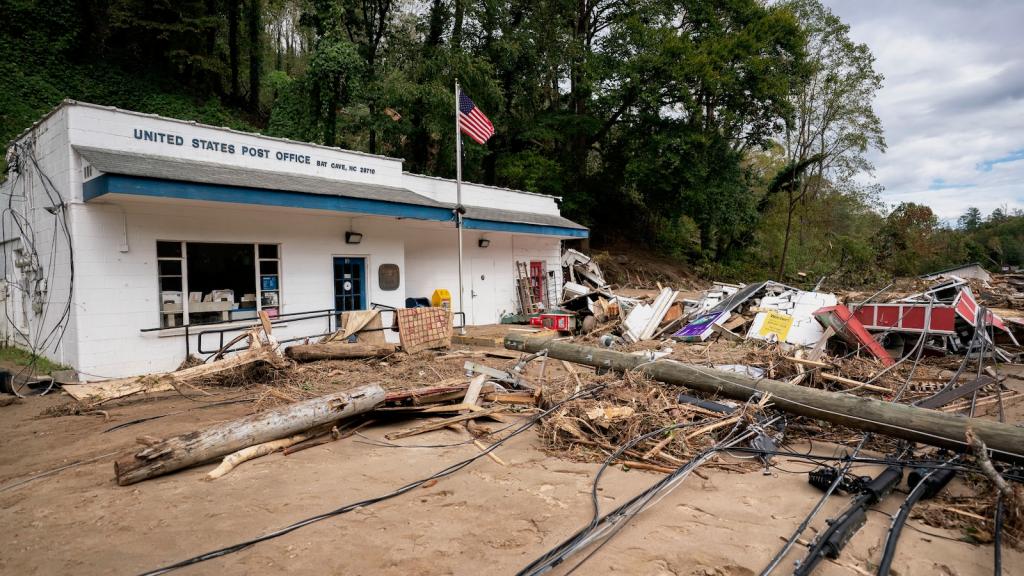 A downed utility pole and other debris are piled outside the post office in Bat Cove, North Carolina in the wake of Hurricane Helene.