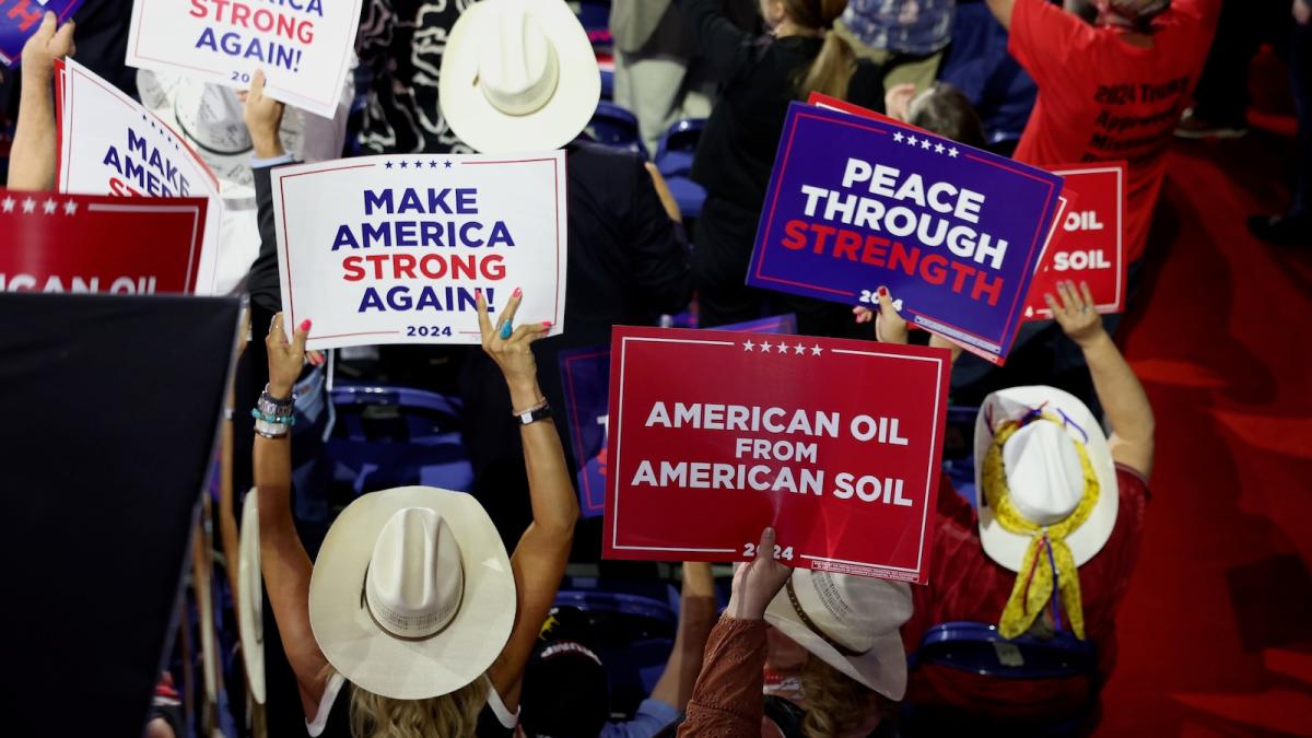 People hold signs that read "American Oil from American Soil" and "Make America Strong Again" on the third day of the Republican National Convention at the Fiserv Forum on July 17, 2024 in Milwaukee, Wisconsin.