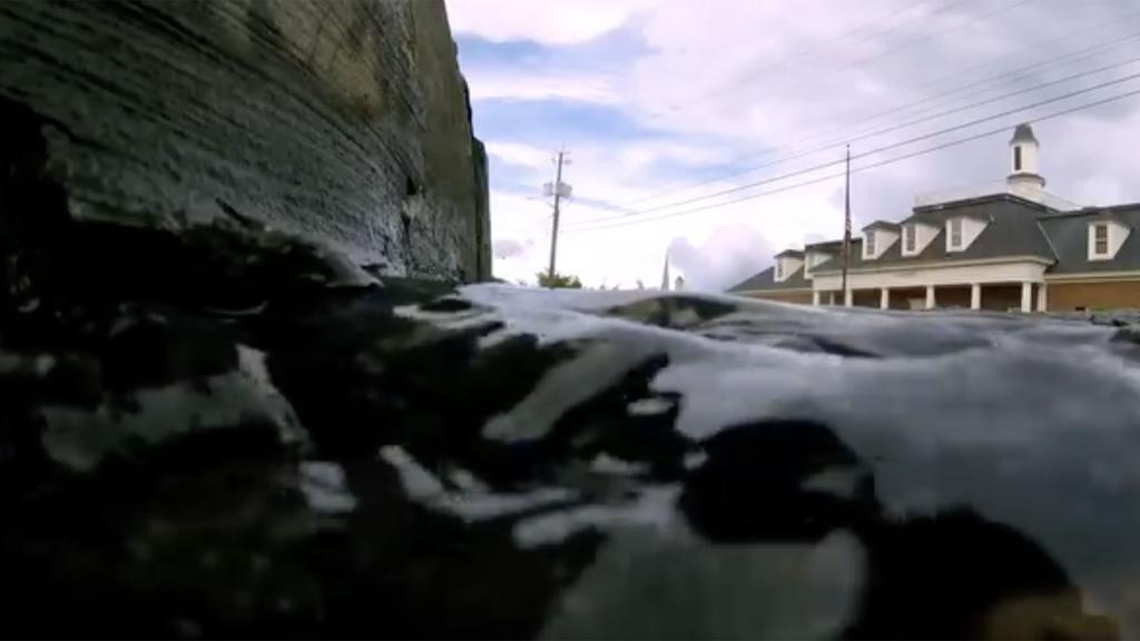 A screenshot of a video with rising water and a historic building