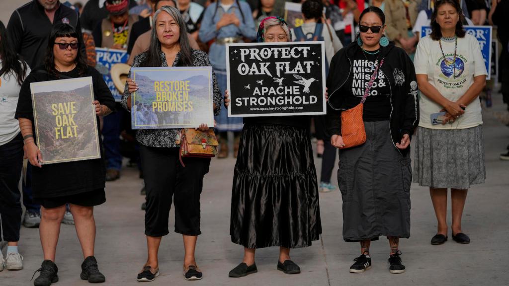 Protesters holding signs that say 