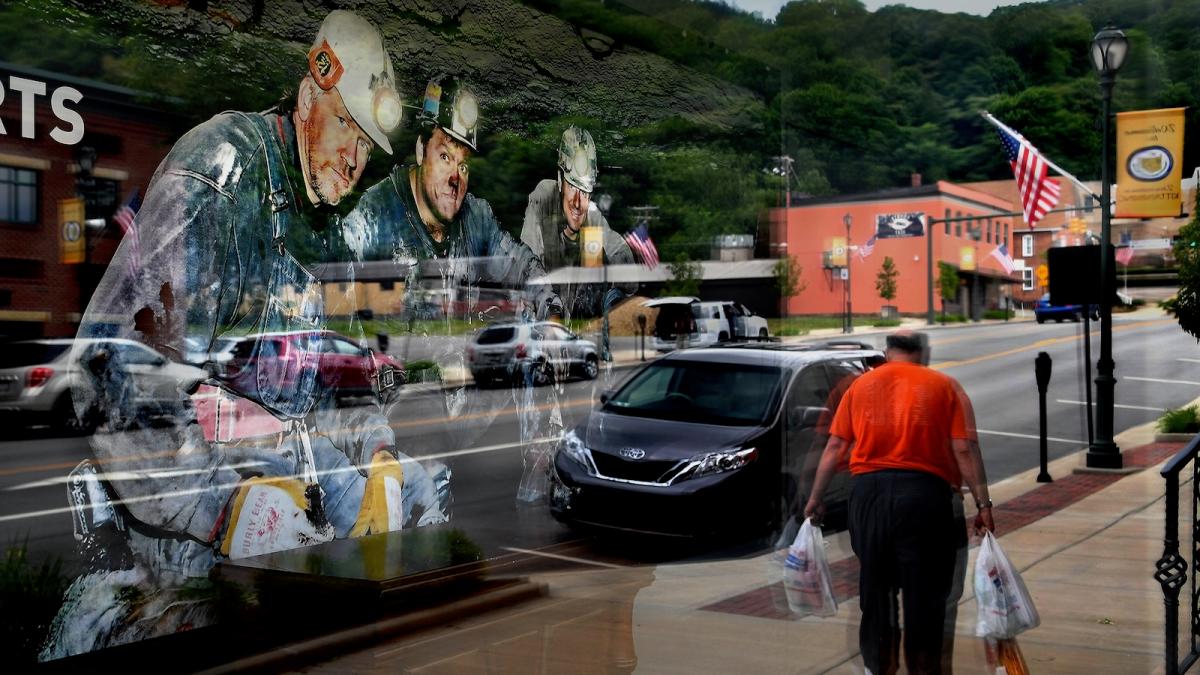 A mural showing three coal miners is seen through the window of a business in Kittanning, Pennsylvania.