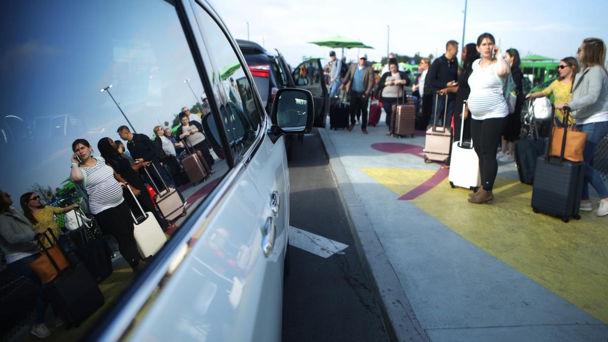 Passengers at Los Angeles International Airport wait to board Uber vehicles.