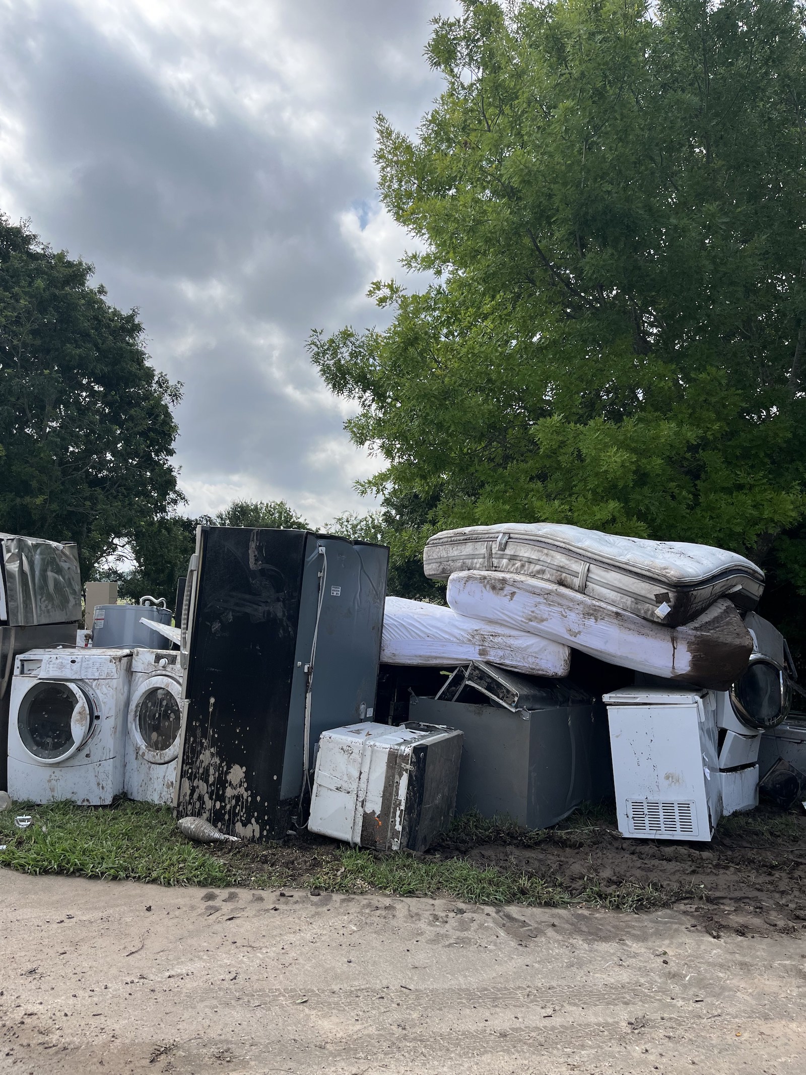 a pile of mattresses and washing machines from flood-damaged houses