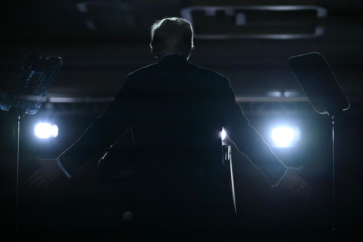 a backlit silhouette of Donald Trump who is facing away from the viewer