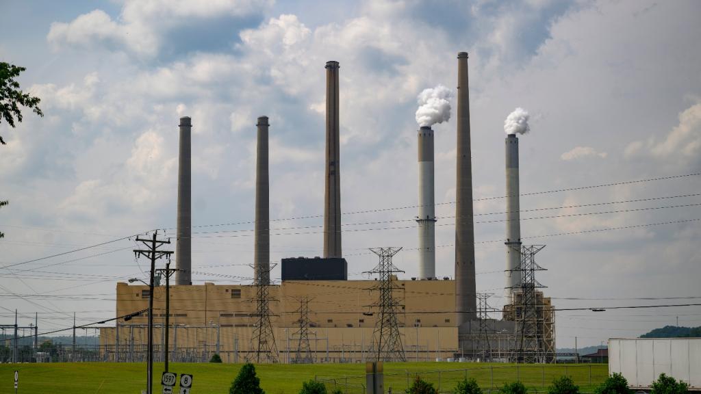 A large brown building is surrounded by smokestacks