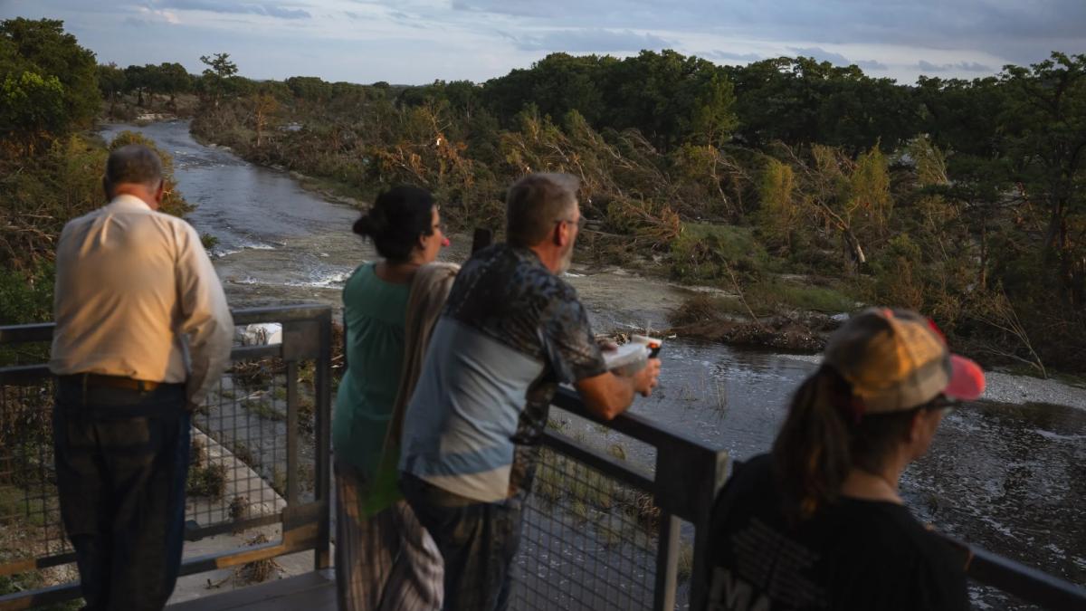 Men and women look at a river from the banks