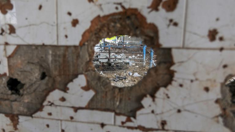 A view through a bullet hole of a damaged animal farm after an Israeli attack in Gaza City