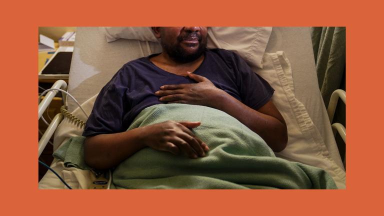 Man sitting in a hospital bed with his hand resting on his chest