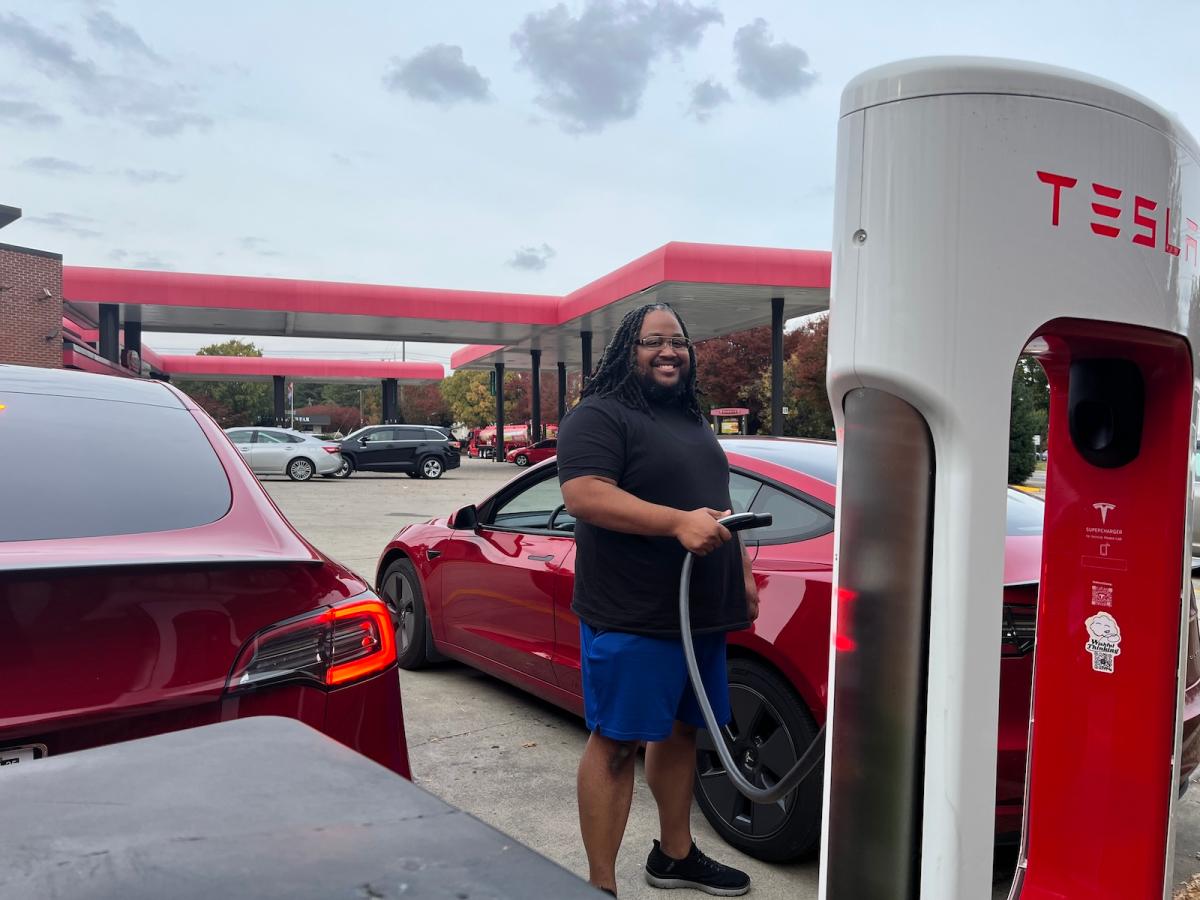 A man charges his Tesla model 3 at a charging station at a Sheetz convenience store