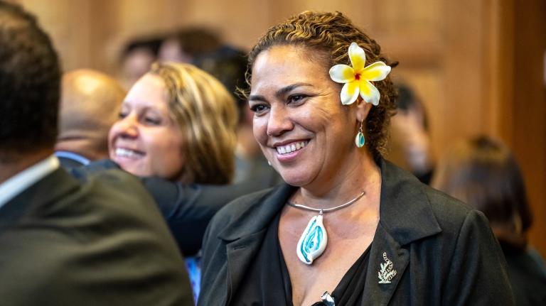 Close up of a smiling woman with a flower tucked behind her ear