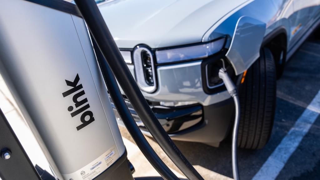 A Rivian electric pickup truck is seen plugged into a charger.