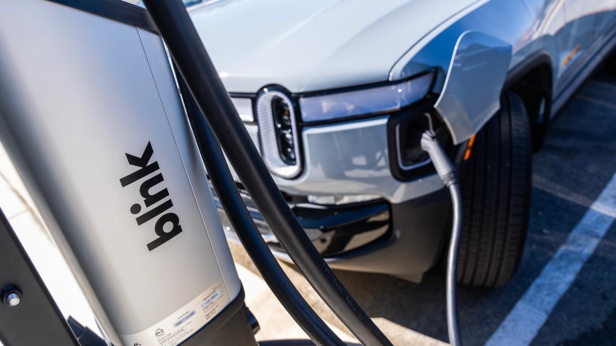 A Rivian electric pickup truck is seen plugged into a charger.