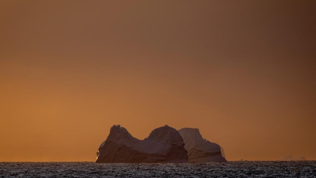 An Antarctic glacier in the Southern Ocean is seen at dusk.