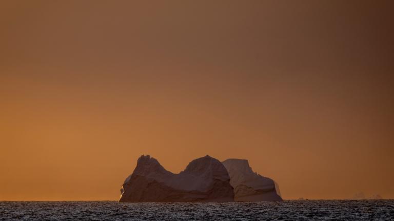 An Antarctic glacier in the Southern Ocean is seen at dusk.