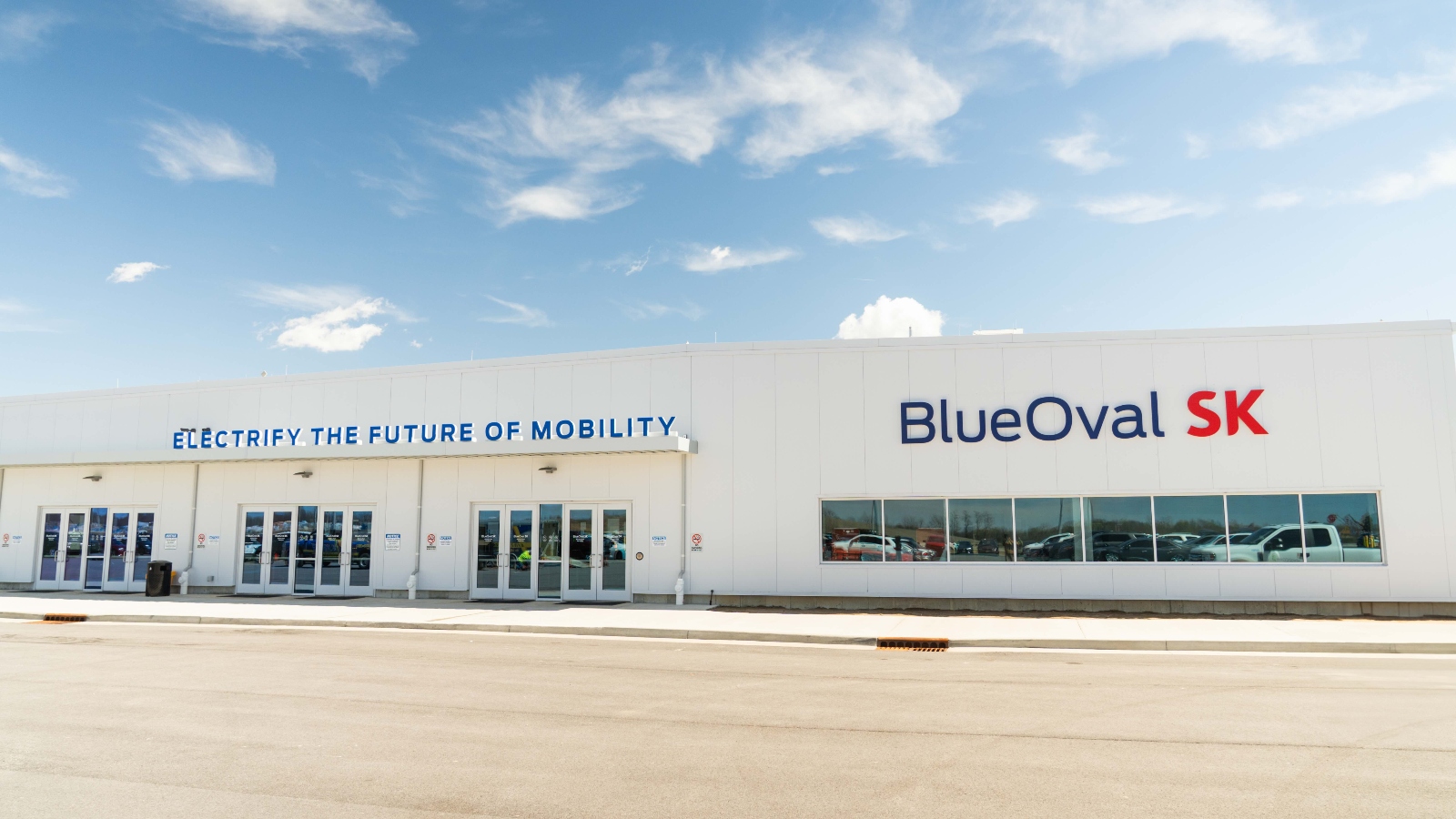 The exterior of a factory that is painted white and reads Blue Oval