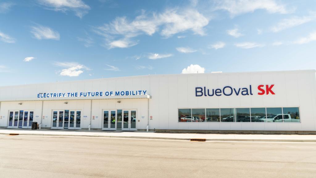 The exterior of a factory that is painted white and reads Blue Oval