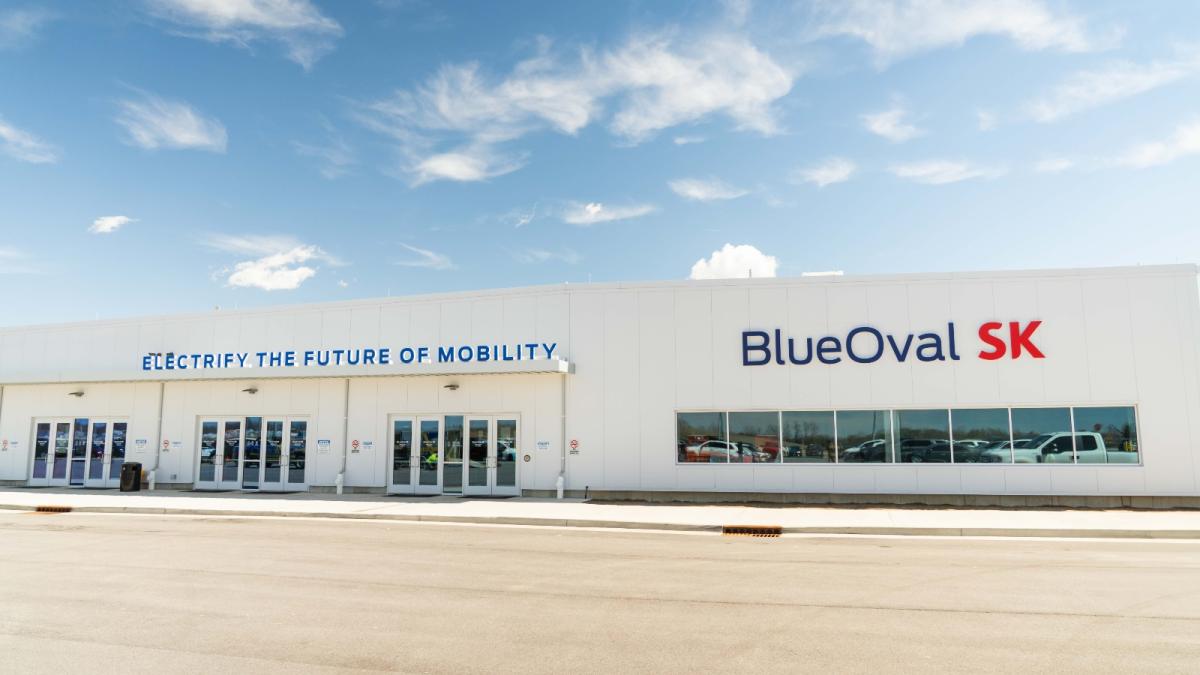 The exterior of a factory that is painted white and reads Blue Oval