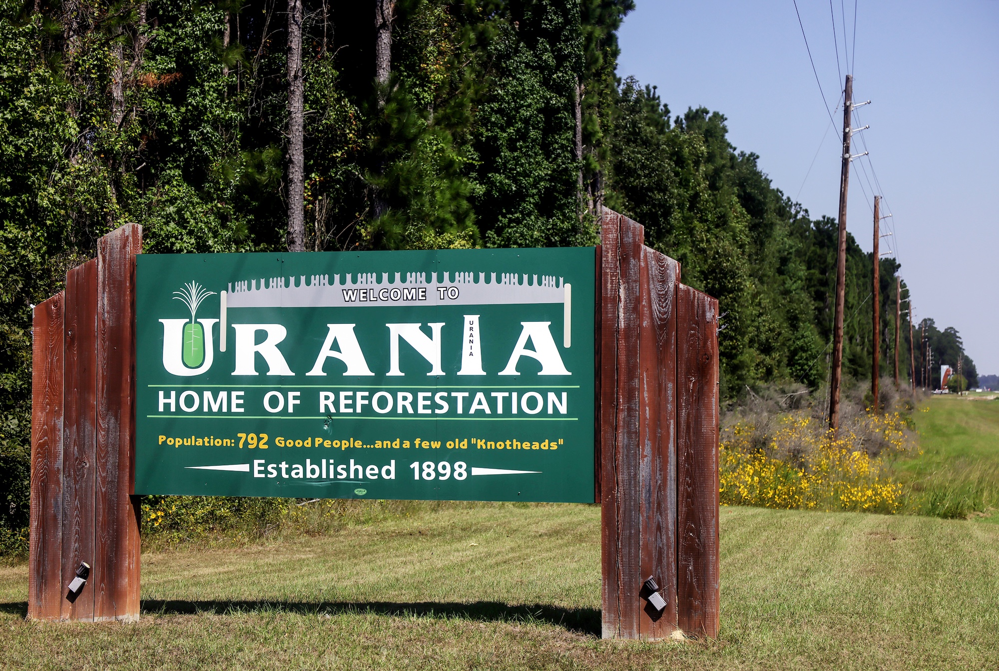 A sign says 'urania, home of reforestation'