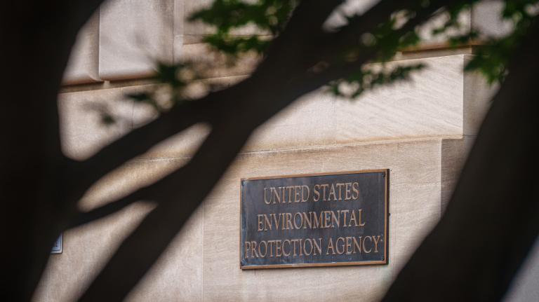 A photo of the Environmental Protection Agency sign peeking out behind a tree