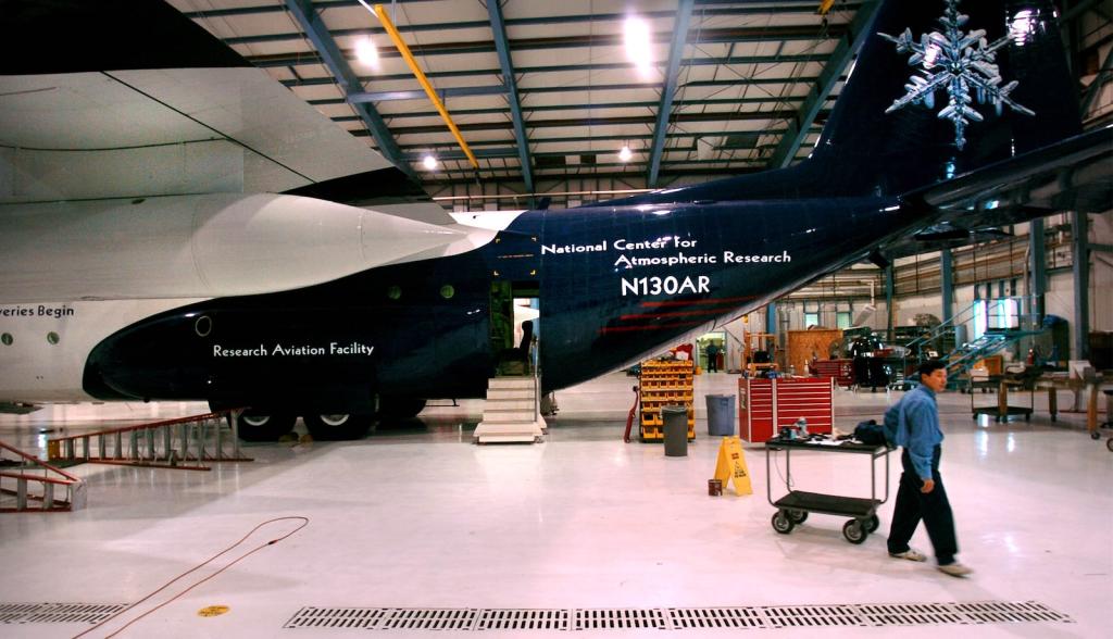 A photo shows a worker servicing a research plane inside the National Center for Atmospheric Research
