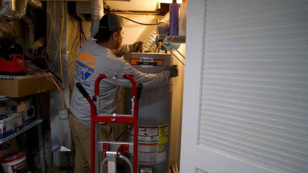A technician at heating, cooling and plumbing company John G. Webster, removes a gas water heater from a home in Washington, DC, on August 28, 2024.